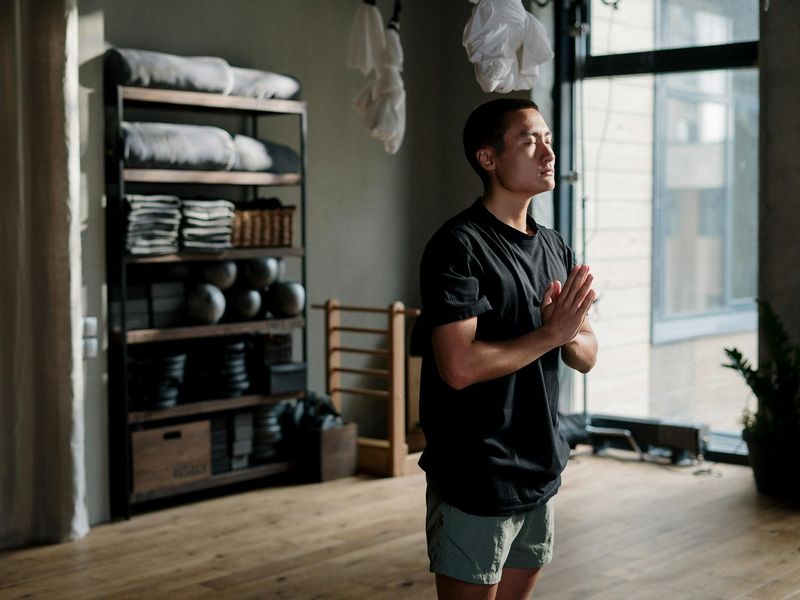 Minimalist yoga studio with wooden floor and sunlight.